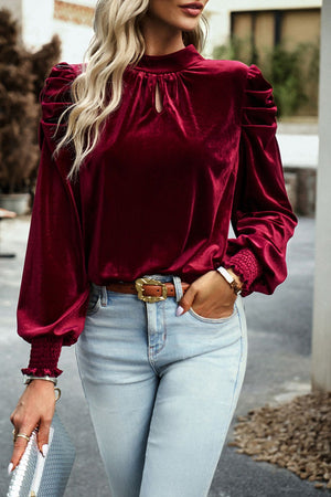 Burgundy velvet blouse with puff sleeves, keyhole neckline, and smocked cuffs.