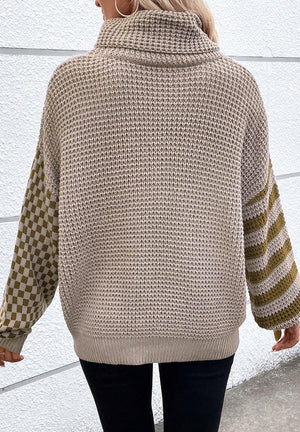 Mocha knit turtleneck sweater with checkerboard and stripe sleeves.
