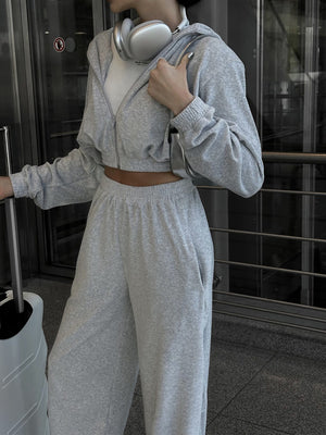 Light gray cropped zip hoodie and wide leg sweatpants set with a white t-shirt.