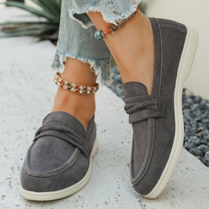 Grey slip-on loafers with a round toe and decorative knot detail.