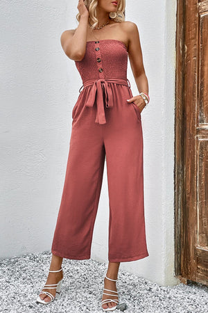 Smocked bodice wide-leg jumpsuit in watermelon pink with button detail and self-tie belt.
