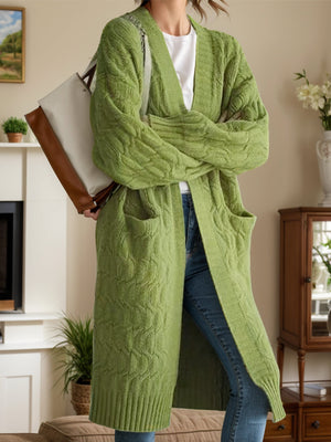 Green cable knit duster cardigan with pockets and a cascade front, made of acrylic.