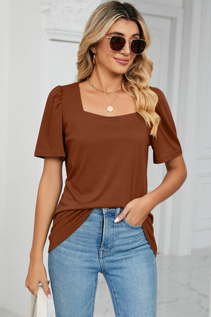 Caramel tee with square neck and sculpted puff sleeves, styled with jeans.