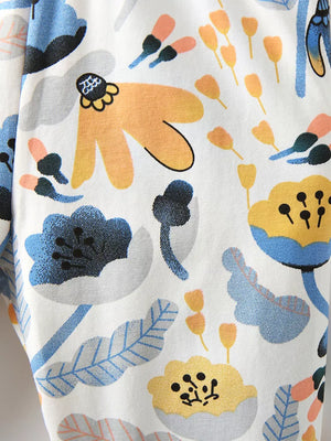 Toddler pants with a whimsical floral print in blue, yellow, and orange on white cotton.
