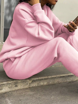 Blush pink athleisure sweatshirt and pants set with crewneck and cuffed sleeves.