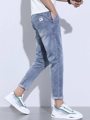 Light blue washed skinny jeans with cuffed ankles and adjustable drawstring detail.
