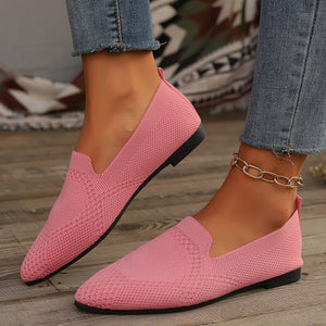 Pink breathable knit pointed-toe flats with a low heel and chain ankle bracelet.