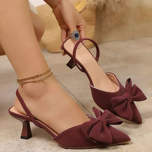 Chic bow-embellished kitten heel pumps in red with slingback strap and pointed toe.