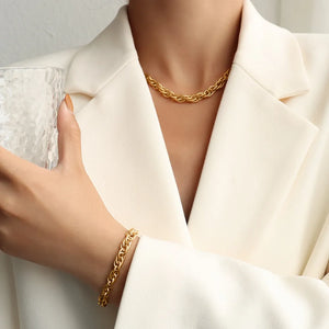 Gold textured rope chain necklace and matching bracelet worn with a white blazer.