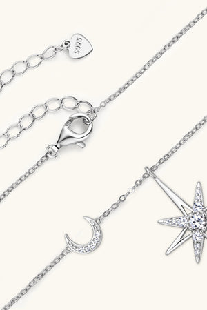 Silver celestial starburst and crescent moon pendant necklace with cubic zirconia details.