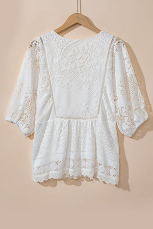 White lace peplum blouse with scalloped hem and puff sleeves.
