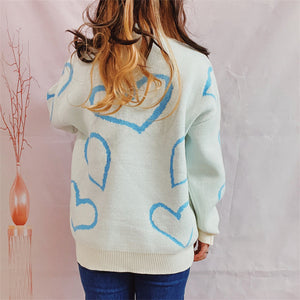 Pastel blue knit sweater with a heart pattern, crew neck, and ribbed trim.