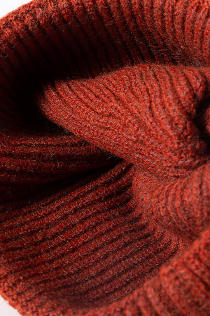 Ribbed acrylic beanie in rust color, showing texture detail.