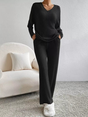 Black ribbed knit V-neck loungewear set with long sleeves and flared pants.