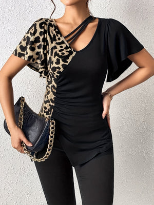 Asymmetric leopard paneled black blouse with cutout neckline and ruched side detail.