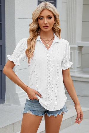 White eyelet polo blouse with short puff sleeves and ruffled cuffs.