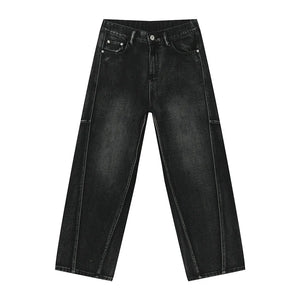 Dark wash denim trousers with exaggerated seam details and a wide leg.