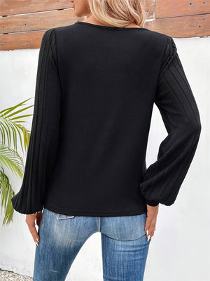 Black ribbed sleeve top with a casual fit and long sleeves.