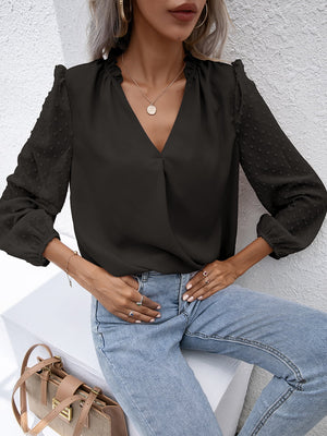 Black Swiss dot sleeve gathered blouse with V-neck and ruffled neckline.