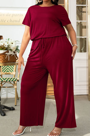 Wine relaxed fit jumpsuit with short sleeves, drawstring waist, and wide legs.