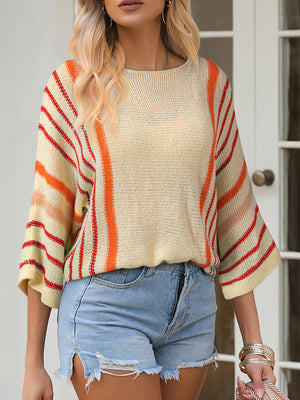 Colorblock sleeve knit pullover with orange and red stripes on a cream background.