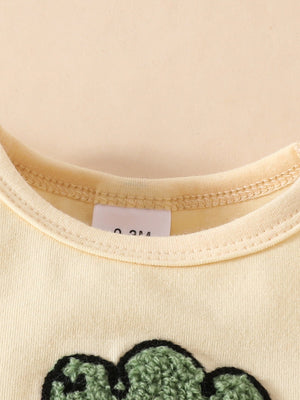 Yellow baby bodysuit with charming carrot appliqué detail and size tag