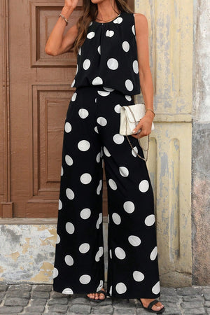 Black polka dot sleeveless top and wide-leg pants set with a white clutch.