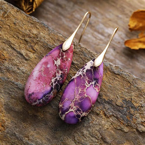 Marbled gemstone teardrop earrings in lavender and gold with unique natural patterns.