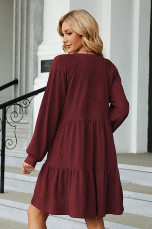 Burgundy textured babydoll mini dress with voluminous sleeves and tiered hem