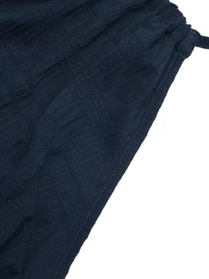 Navy ruched midi dress with halter tie back detail and textured fabric.
