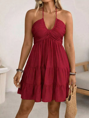 Red halter neck ruffled mini dress with tiered skirt and deep V-neck.