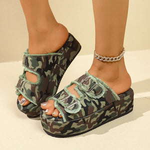 Denim buckle platform slides in green camouflage with frayed trim and silver buckles.