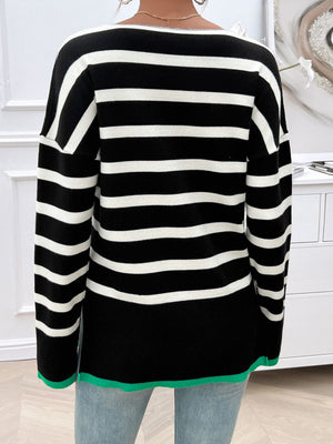Black and white striped oversized knit top with a green hem detail.
