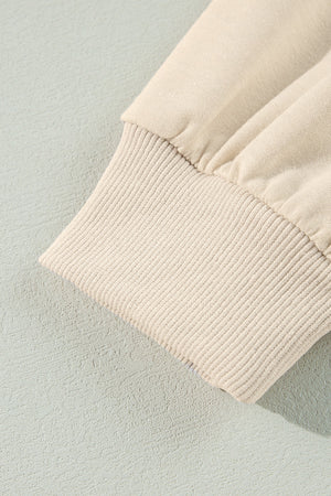 Cream sweatshirt with ruffled shoulder detail and ribbed cuffs.