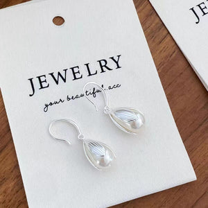 Lustrous pearl drop earrings with silver-tone metal settings, delicate and elegant.