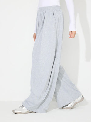 Light gray pleated drape palazzo trousers with a wide leg and elastic waistband.