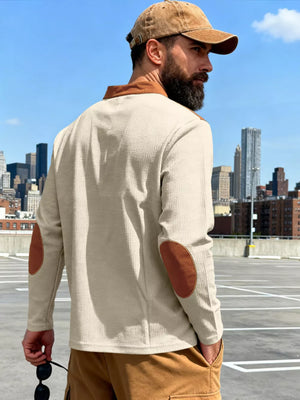 Men's beige long-sleeve t-shirt with brown elbow patches and collar detail.
