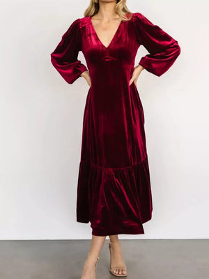 Burgundy velvet midi dress with V-neck, puff sleeves, and tiered skirt.
