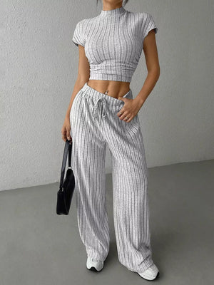 Grey ribbed knit set with mock neck crop top and drawstring wide leg pants.