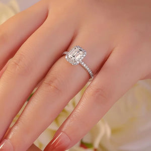 Radiant Moissanite engagement ring in silver with emerald-cut center stone and halo.