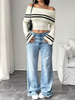 White off-shoulder cropped knit sweater with black stripes on flare sleeves and neckline.