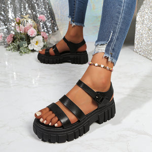 Black open-toe platform sandals with three straps and buckle closure.