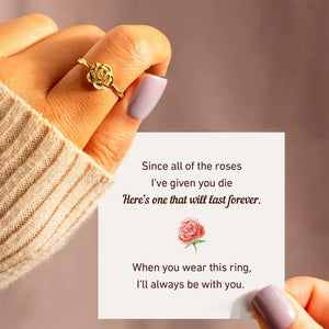 18K gold ring with a sculpted rosebud detail on a woman's finger.
