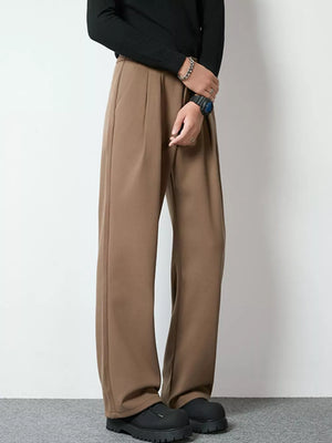 Men's dark brown wide-leg pleated trousers with a relaxed fit.