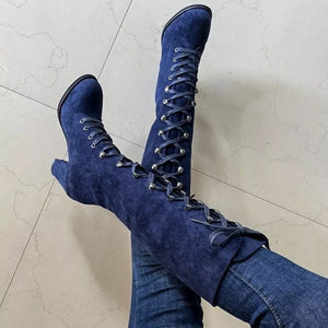 Blue suede lace-up block heel boots with silver eyelets and tie detail.