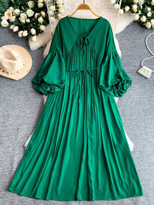 Green polyester maxi dress with balloon sleeves, tie neckline, and cinched waist.