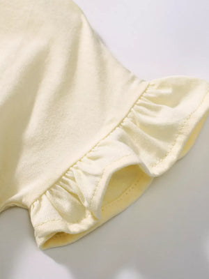 Baby dress sleeve detail with ruffled trim in light yellow cotton fabric.
