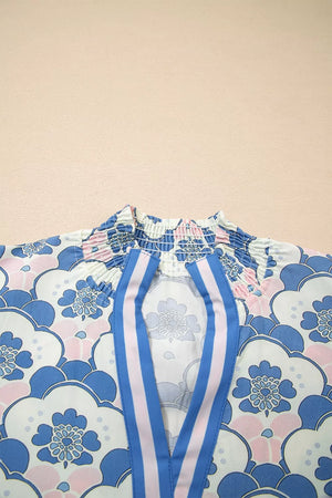 Blouse with floral print, smocked neckline, and blue and pink striped placket.