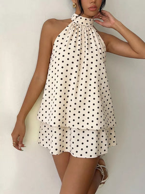 Chic polka dot halter mini dress in apricot with a tiered skirt and gathered neckline.