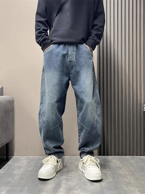 Oversized blue washed men's jeans with tapered cuffs and a baggy fit.